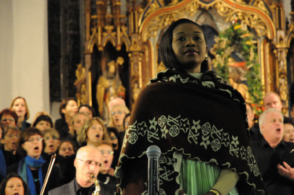 Buki singing in a church before a congregation
